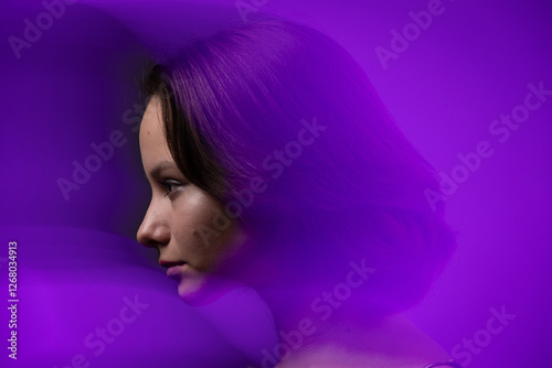 Obraz na płótnie Beauty studio portrait of beautiful girl against violet background. Motion blur added intentionally w salonie