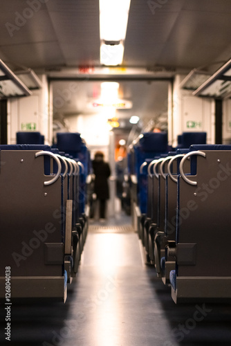 Inside a passenger train carriage. Long rows of seats stretch into the distance, symmetrical photo of an empty regional passenger train. German regional passenger train, inside view