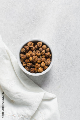 Overhead view of dried tiger nuts in a white bowl, top view of Yellow Nutsedge in a bowl photo