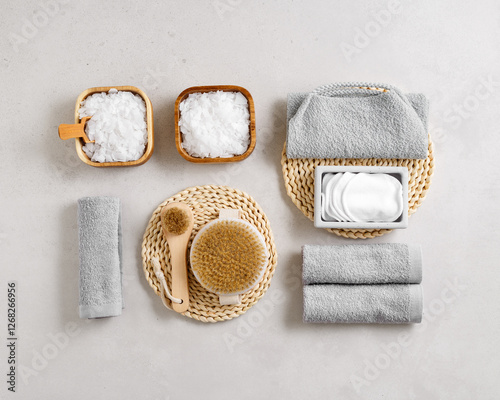 Top view Spa or bath accessories on grey background. Sea salt, cotton towels, natural brushes, wooden massagers, washcloth, relaxation, self-care routines, or eco-friendly beauty products, above photo