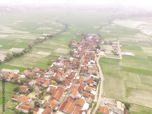 Cikancung, Indonesia. Aerial Landscape view of a remote village surrounded by rice field patches. High angle view of Residential District and agricultural fields. Panorama rural and suburban. Asia photo