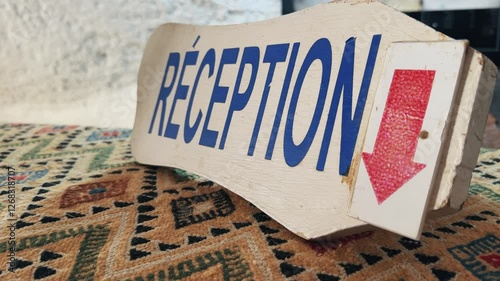 Hotel reception sign placed atop an intricately patterned fabric texture in Matmata, Tunisia, Africa
