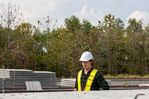 Wallpaper Mural Male civil engineer in safety suit is checking the quality of slabs and precast floorboards in a factory. Construction worker uses a check list to inspect the precast products. Torontodigital.ca