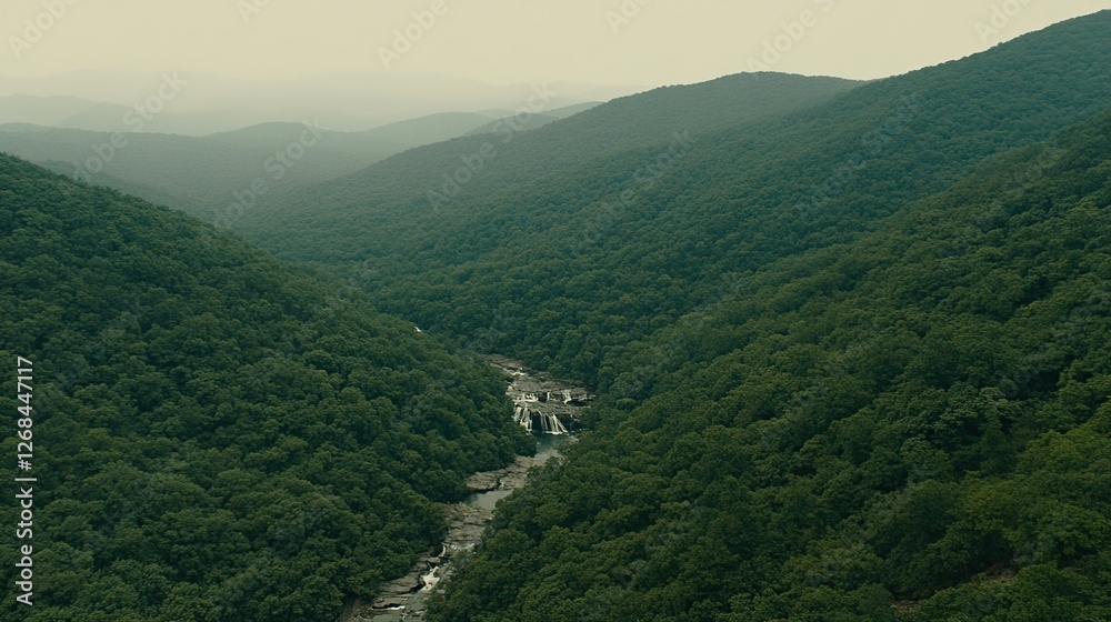 Fototapeta premium Aerial view of waterfall cascading through mountain valley, misty background, nature documentary