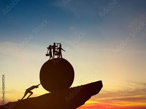 Carrying the burden of the team, a businessman pushes a rock up a mountain for his colleagues