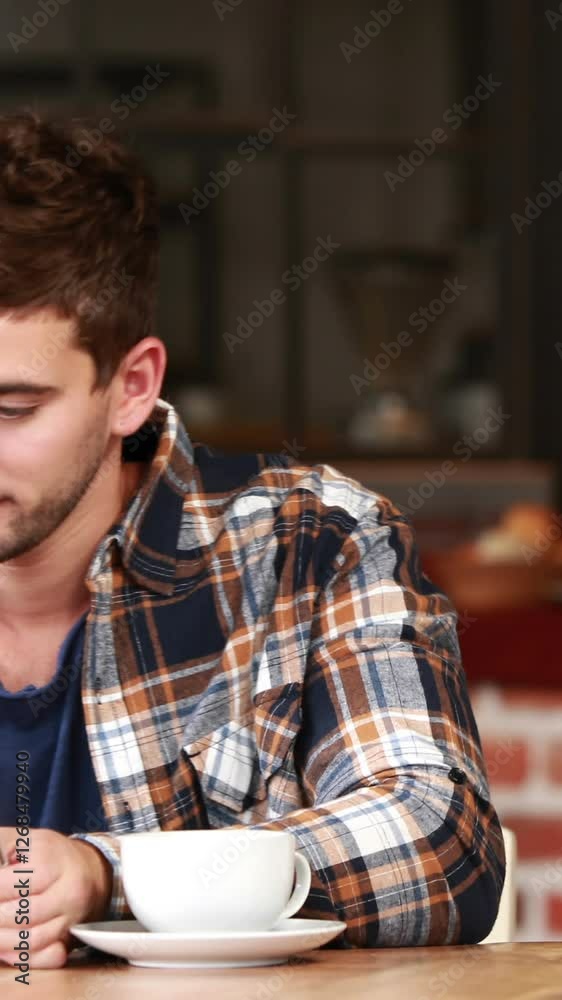 Smiling hipster man using a tablet and sipping coffee Smiling hipster man using a tablet and sipping coffee