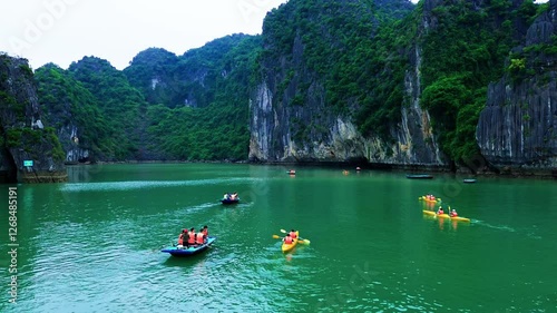 Aerial drone footage kayaking on the emerald waters of Halong Bay.