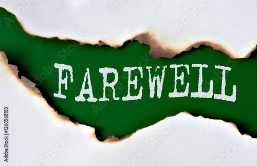 FAREWELL - word on green paper against the background of a sheet of paper damaged by fire