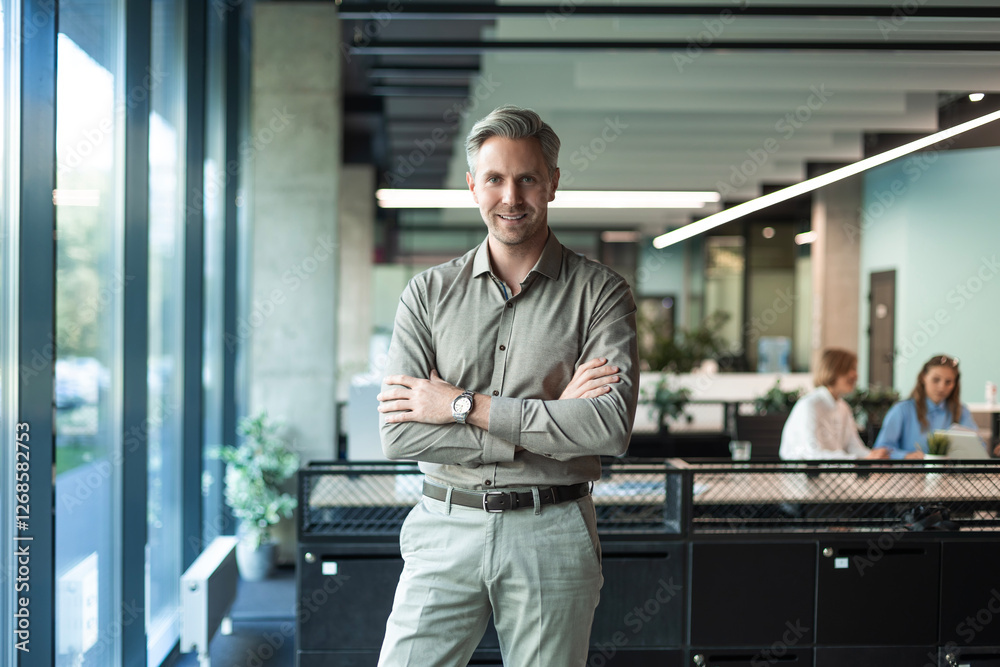 Handsome successful businessman looking camera hands crossed friendly chief standing at modern office indoors Handsome successful businessman looking camera hands crossed friendly chief standing at modern office indoors