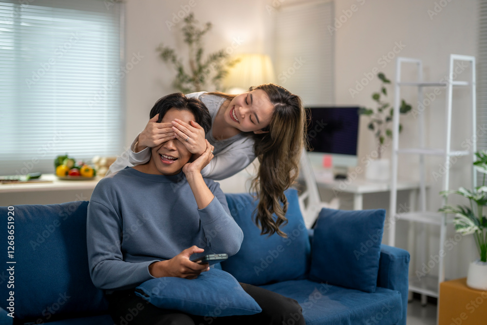 Fototapeta premium A man and a woman are sitting on a blue couch