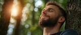 Man enjoys peaceful moment in forest, experiencing nature and tranquility during golden hour
