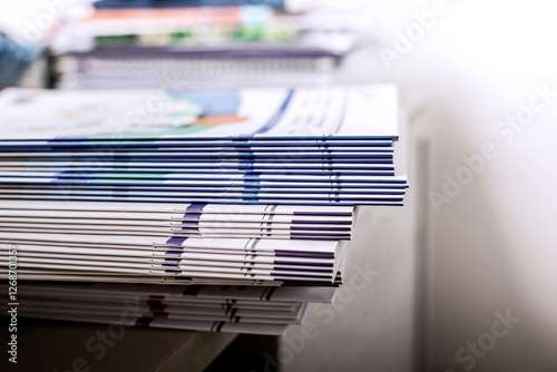 Stack of magazines on the desk in the office. Selective focus.