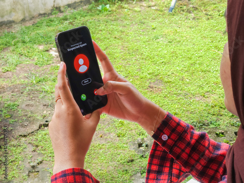 A young woman receiving a spam call from a cellphone (The user interface design used is self-made, created using vector editing software).