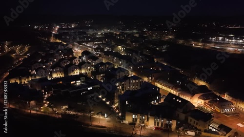 Wallpaper Mural Illuminated modern residential neighborhood at night, showcasing warm lights, cozy homes, and surrounding cityscape. Torontodigital.ca