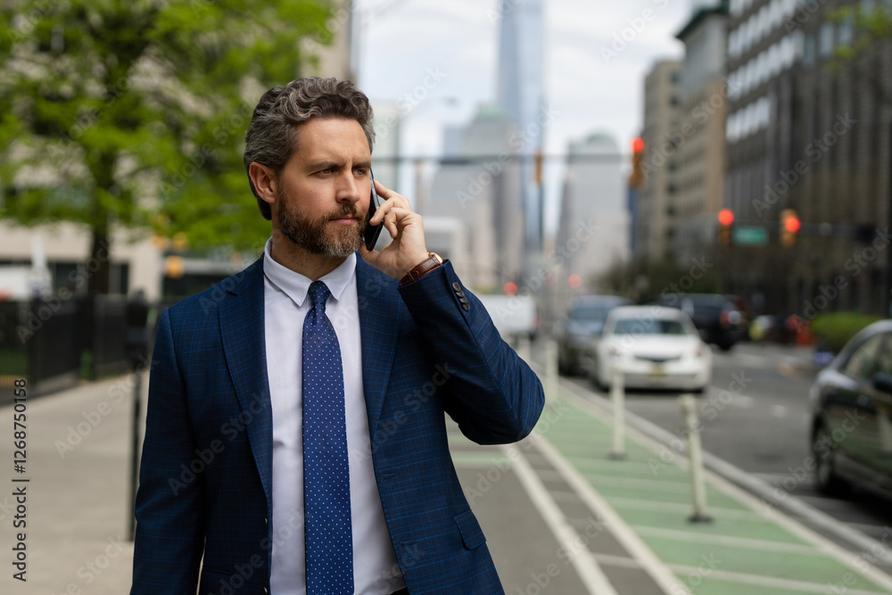 Businessman with phone outdoor. Business talk. Man walk down street talking on the phone. Serious Man in suit talking on the phone. Outdoor portrait of Businessman with smartphone. Businessman with phone outdoor. Business talk. Man walk down street talking on the phone. Serious Man in suit talking on the phone. Outdoor portrait of Businessman with smartphone.