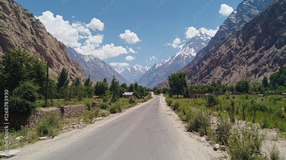 Fototapeta premium Mountain Road Through Valley with Snow-Capped Peaks