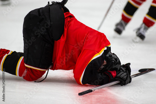 Ice hockey player injured and lying down on the ice