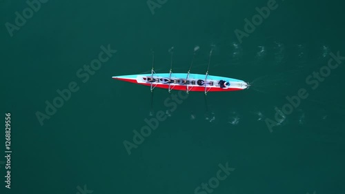 Sport Canoe with a team of four people rowing on tranquil water, Aerial view. High quality 4k footage