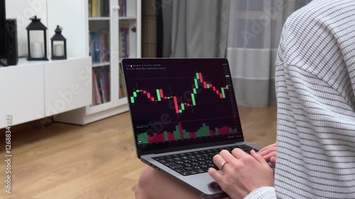 A woman is analysing stock market data on her laptop
