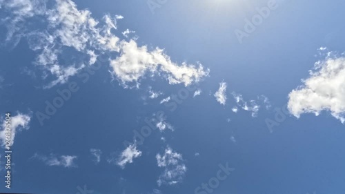 4K Timelapse of clouds passing overhead, with beautiful sunlight filtering through the top of screen.