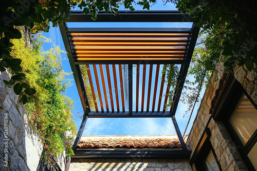 Outdoor structure provides shade with modern design. The pergola complements the natural stone and greenery, blending function and style. photo