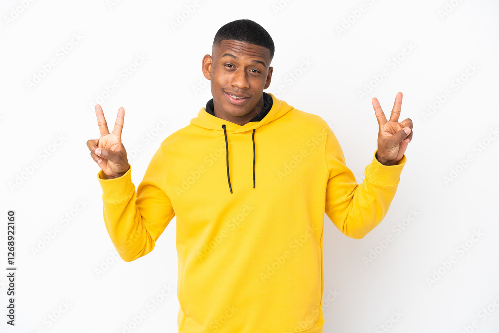 Fototapeta premium Young latin man isolated on white background showing victory sign with both hands