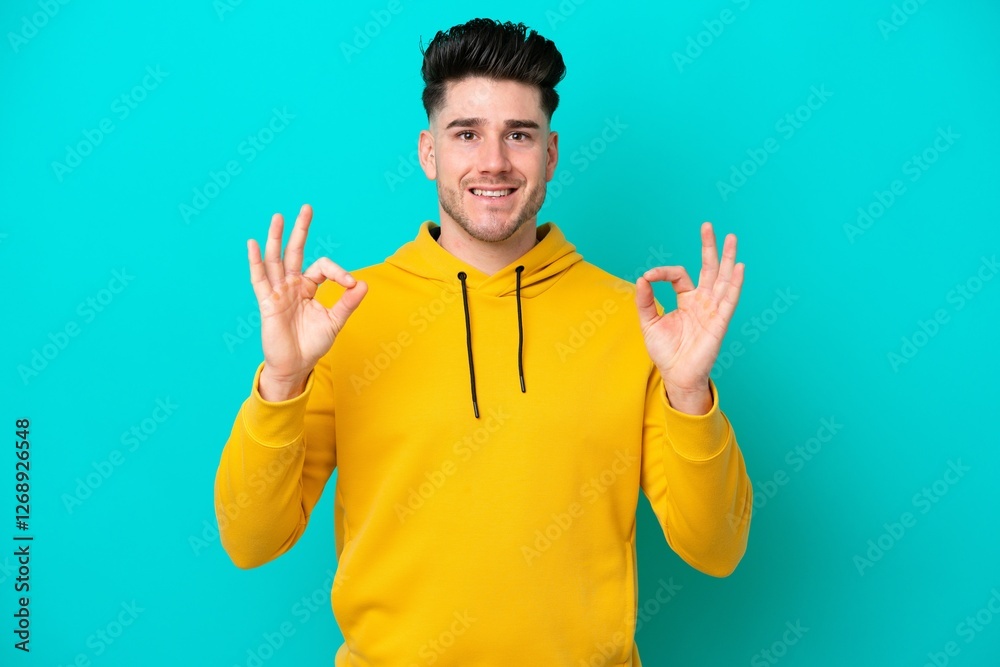 Young caucasian man isolated on blue background showing ok sign with two hands Young caucasian man isolated on blue background showing ok sign with two hands