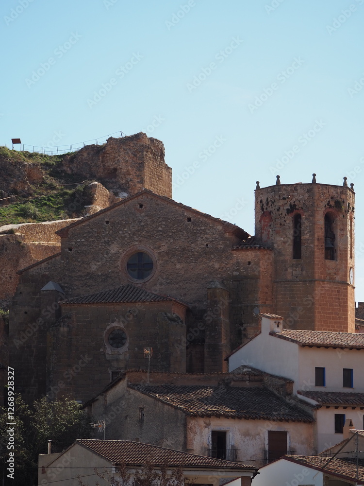 Historic stone church and medieval ruins in Alpuente, Spain, under a clear blue sky Historic stone church and medieval ruins in Alpuente, Spain, under a clear blue sky