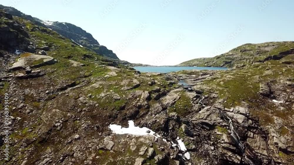 Aerial View of a Rocky Mountain Pass with Patches of Snow and Sparse Vegetation Aerial View of a Rocky Mountain Pass with Patches of Snow and Sparse Vegetation