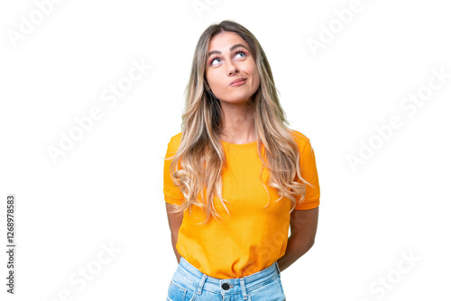 Young Uruguayan woman over isolated background and looking up