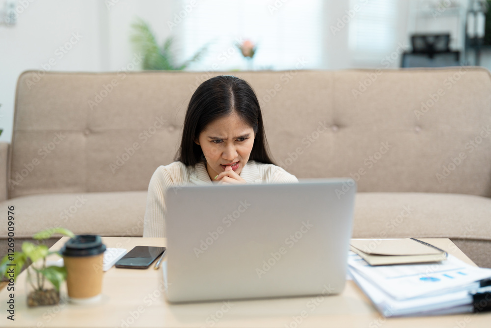Concerned woman biting nails while working on laptop at home. Concerned woman biting nails while working on laptop at home.