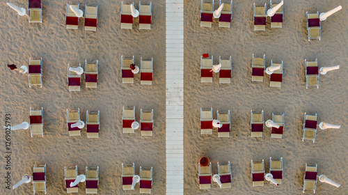 Top down view of closed umbrellas in the evening in summer at the beach of Marina di Ostuni, Puglia, Italy