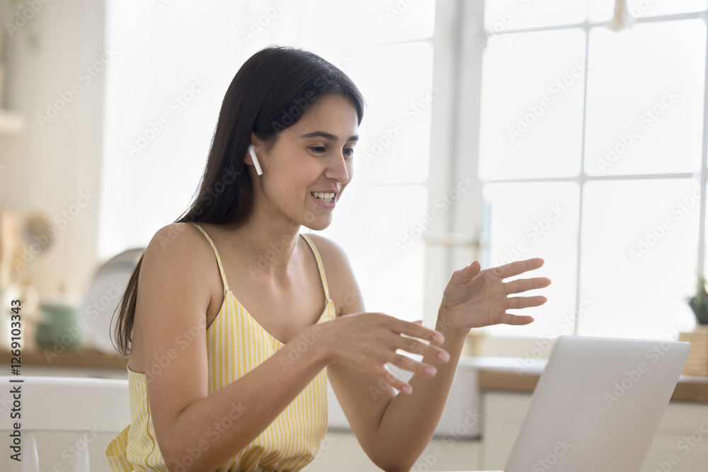 Virtual communication for work or study. Confident young woman wear wireless earbuds speak into notebook webcam consult client on distance talk with teacher via video call present idea at online event Virtual communication for work or study. Confident young woman wear wireless earbuds speak into notebook webcam consult client on distance talk with teacher via video call present idea at online event