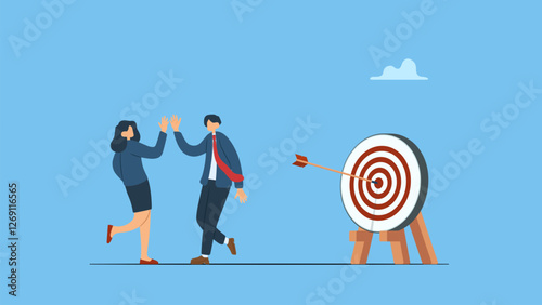 Two happy employees claping hands, hi five  each other next to a target board simbolyzes team success winners, hi five or congratulation on business goal achievement, collaboration or encouragement.