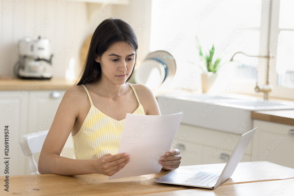 Reading and analyzing. Pensive young woman think over paper documents at home office desk consider terms conditions of loan mortgage agreement contemplate tuition fees according to university contract Reading and analyzing. Pensive young woman think over paper documents at home office desk consider terms conditions of loan mortgage agreement contemplate tuition fees according to university contract