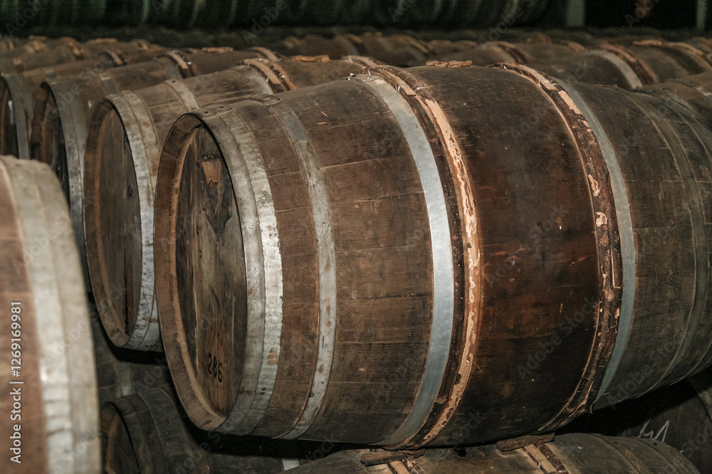 A stack of barrels with the top barrel being the largest. The barrels are made of wood and are stacked on top of each other A stack of barrels with the top barrel being the largest. The barrels are made of wood and are stacked on top of each other