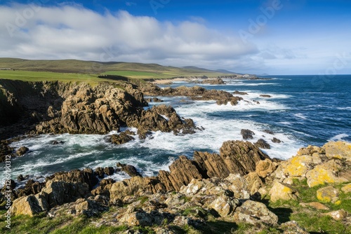 Rugged Coastal Landscape with Rocky Cliffs and Ocean Waves under Blue Sky