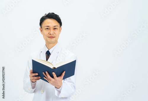 医師、研究者、科学者、専門家、研究、本、勉強、学習、教授、博士、ミドル、ミドルエイジ、中年、30代、40代、男性、日本人、おじさん、書籍、開発、論文、理系、白衣、ビジネス、経営、アドバイザー、アドバイス、辞書、辞典、白バック、切り抜き、コピースペース、広告、笑顔、知識、教育、大学、医学、医療、メディカル、実験、査読、文献、人材、教師、ドクター、先生、薬剤師、診察、人物 photo