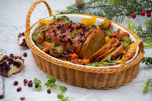 Vegan seitan ham roast, festive meatless dish, along with roasted vegetables photo