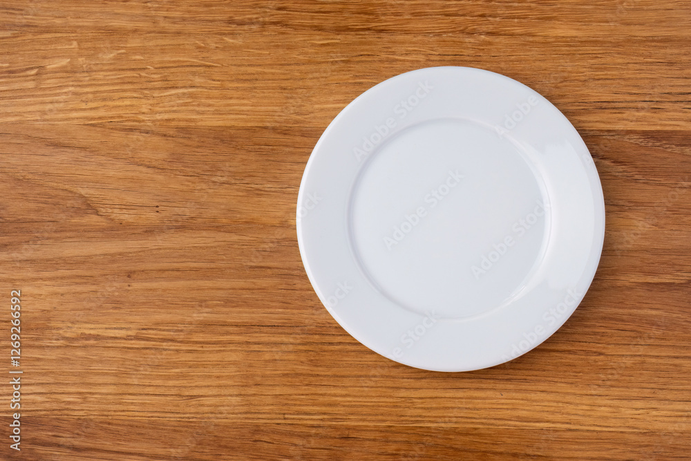 Empty white plate on a wooden table
Empty white plate on a wooden table