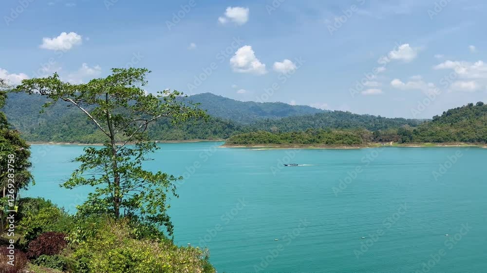 The breathtaking scenery of Cheow Lan Lake in Thailand unfolds with emerald waters, towering limestone cliffs, and lush greenery, creating a serene and majestic atmosphere. The breathtaking scenery of Cheow Lan Lake in Thailand unfolds with emerald waters, towering limestone cliffs, and lush greenery, creating a serene and majestic atmosphere.