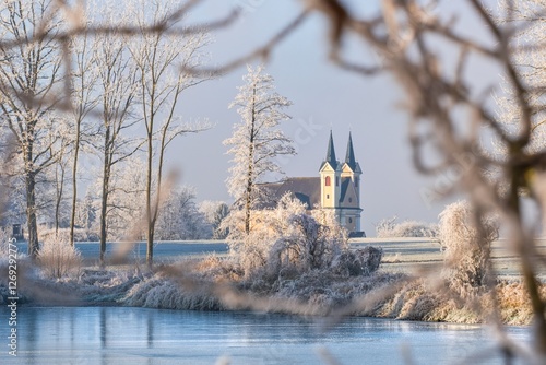 Von Bäumen und Ästen eingerahmte Kirche im Winter