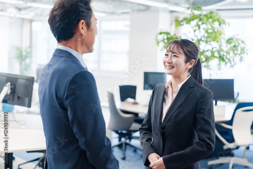 笑顔で上司と話をする若いビジネスウーマン