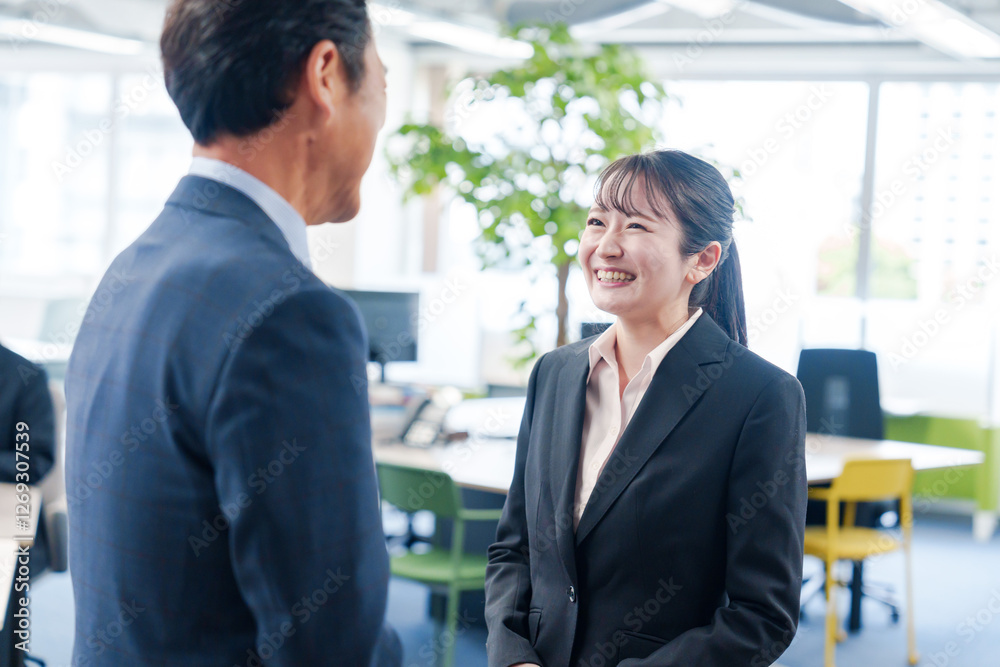 笑顔で上司と話をする若いビジネスウーマン