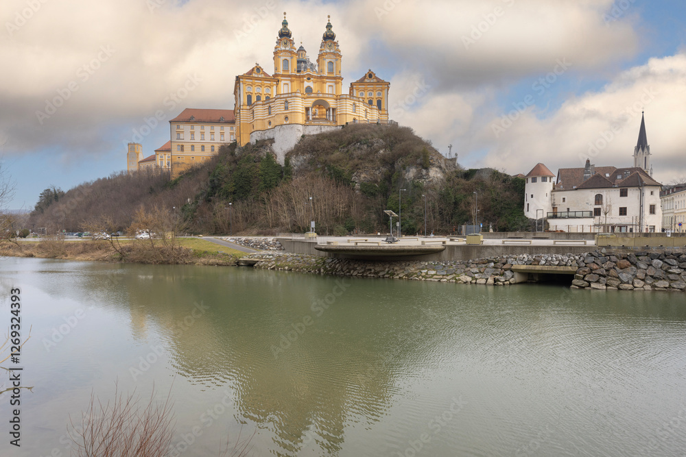 Melk, Austria - February 24, 2023: View of Melk Abbey with Collegiate Church towers, mirror reflection in water. It was founded in 11th century, today's baroque abbey was built in 18th century Melk, Austria - February 24, 2023: View of Melk Abbey with Collegiate Church towers, mirror reflection in water. It was founded in 11th century, today's baroque abbey was built in 18th century