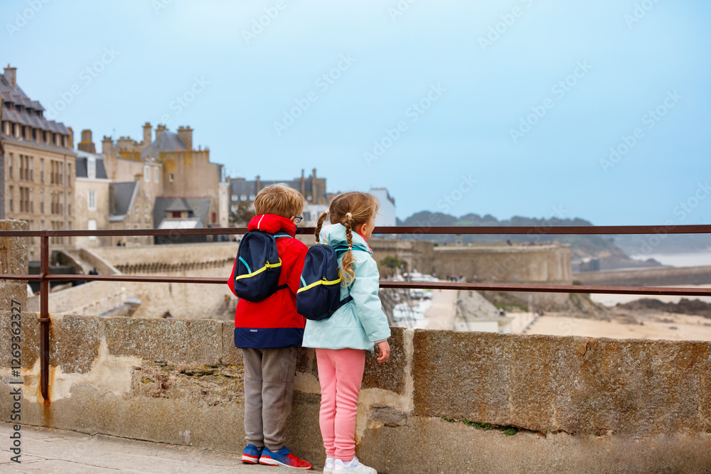 Curious children admire the view from a coastal lookout point
