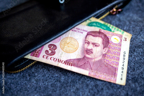 Tajikistani somoni banknotes partially in a wallet