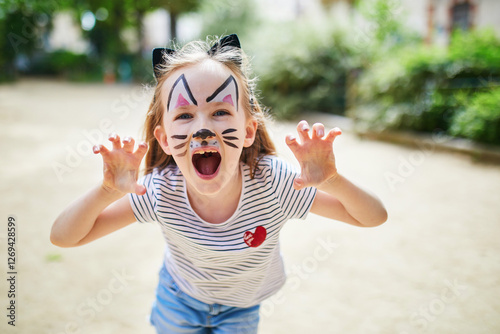Schilderij op canvas Little preschooler girl with cat face painting outdoors