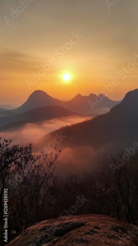 Breathtaking sunset over dramatic mountain peaks with mist in the foreground