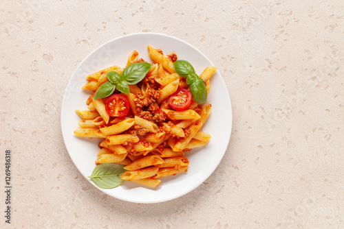 Pasta Penne Bolognese in white plate on light background. Bolognese sauce is classic italian cuisine dish. Popular italian food. Top view